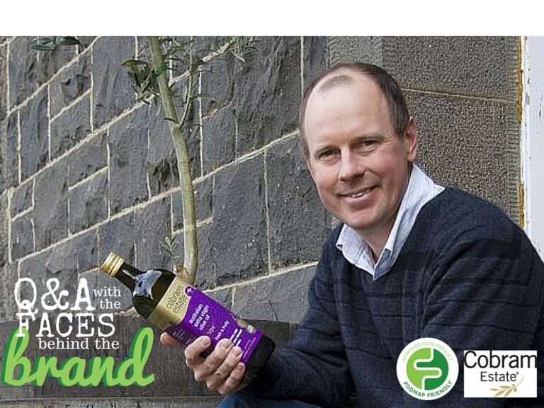 A man in a dark jumper and collared shirt sits outdoors, smiling and holding a bottle of olive oil. The text reads “Q&A with the faces behind the brand,” with Cobram Estate and certification logos at the bottom.
