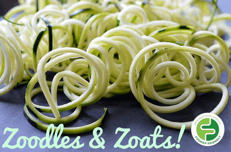 A close-up of spiralised courgette noodles (zoodles) on a dark surface. Text reads Zoodles & Zoats! with a round green FODMAP Friendly logo in the corner.