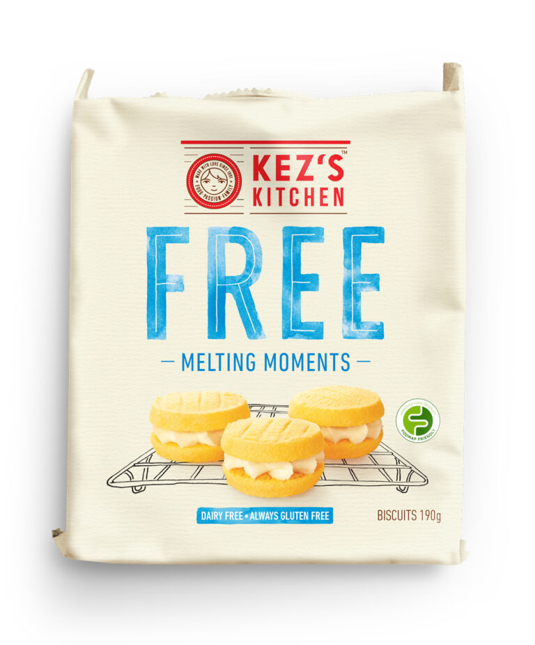 A beige packet of Kez’s Kitchen Free Melting Moments biscuits, featuring three sandwich biscuits with cream filling on a wire rack. The packaging highlights that the product is dairy free and gluten free.