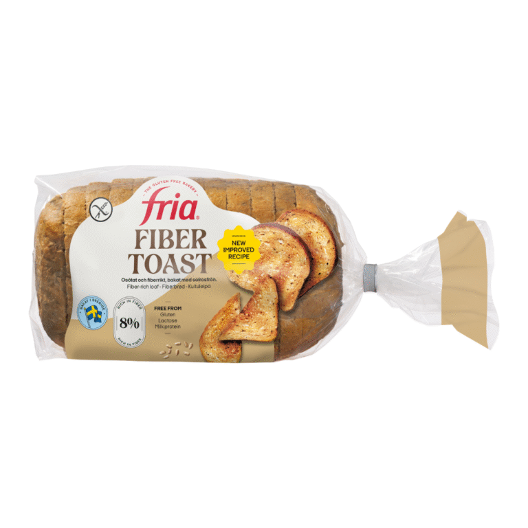 A loaf of Fria Fibre-Rich Toast bread in a clear plastic bag with beige ends. The label highlights its gluten-free status, increased fibre content, new improved recipe, and features an image of two toasted bread slices on the front.