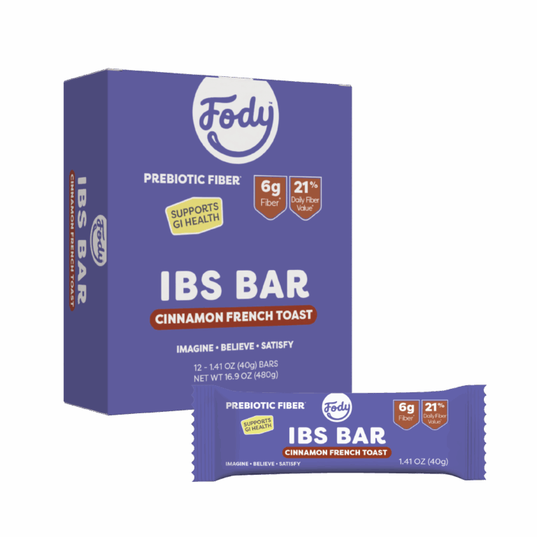 A purple Fody IBS Bar box with High Fibre Cinnamon French Toast flavour text stands behind a single wrapped snack bar. The packaging highlights prebiotic fibre, 6g fibre, 21% daily value, and a supports GI health badge.