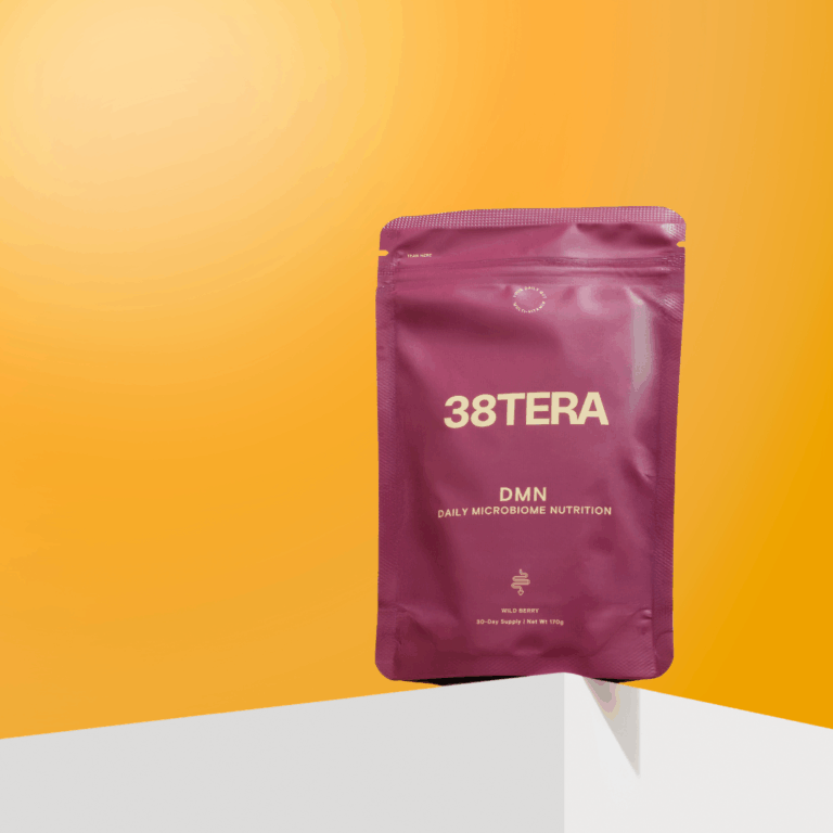 A purple pouch labelled 38TERA DMN Daily Microbiome Nutrition stands upright on a white surface against a gradient orange background, highlighting its FODMAP Friendly formula for daily gut support.