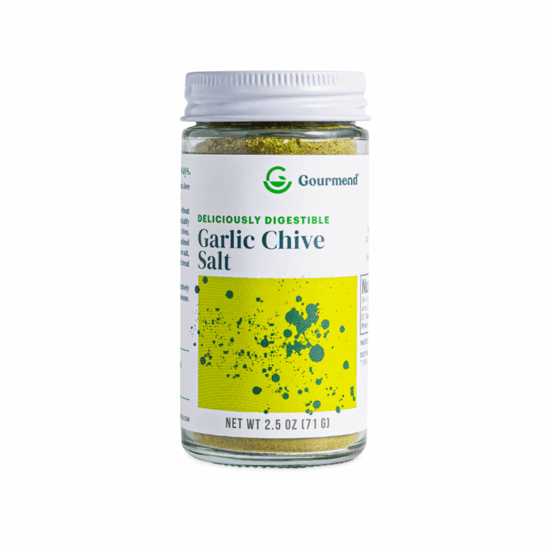 A glass jar of Gourmend Garlic Chive Salt with a green and yellow label, featuring the text Deliciously Digestible and Net Wt 2.5 oz (71 g) on the front. Perfect for elevating any dish with flavourful garlic salt.