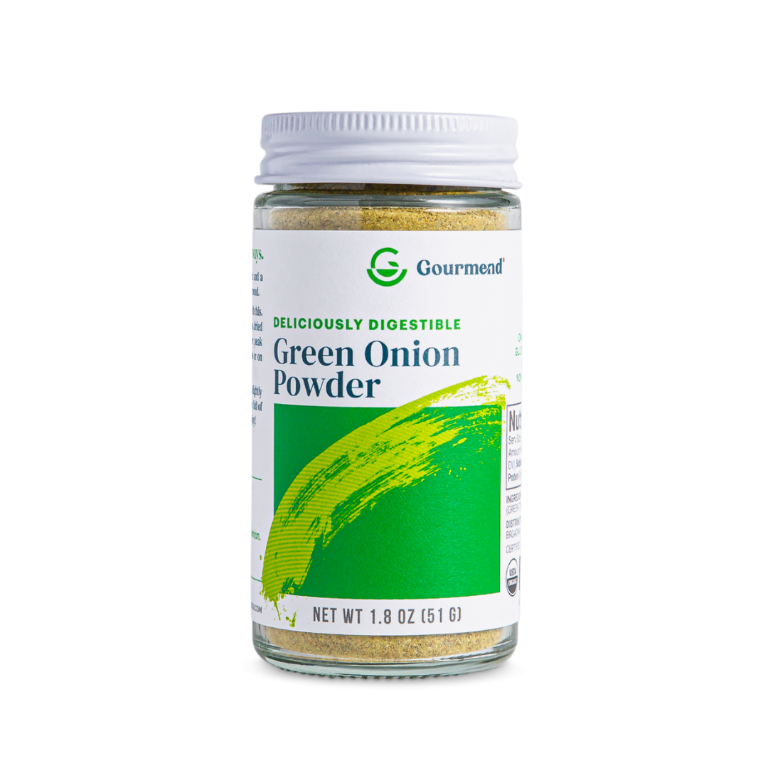 A clear glass jar with a white lid labelled Gourmend Green Onion Powder, featuring green brushstroke art. Blended with chive powder, this 1.8 oz (51g) spice is marked Deliciously Digestible for your gourmet recipes.