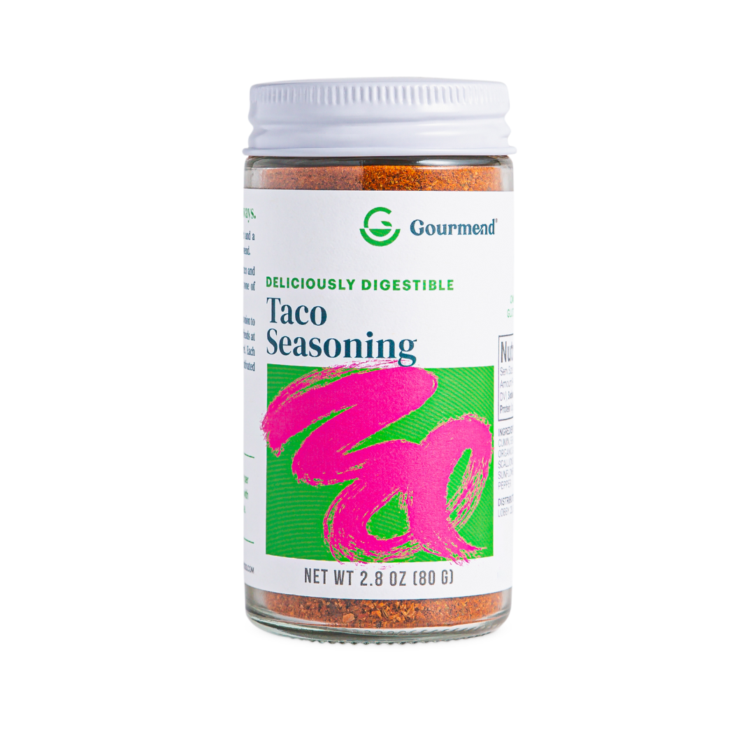 A clear spice jar labelled “Gourmend Taco Seasoning” with a white lid and a colourful label featuring green and bright pink accents. This gourmet seasoning contains 2.8 oz (80g) of flavourful Gourmend spices.