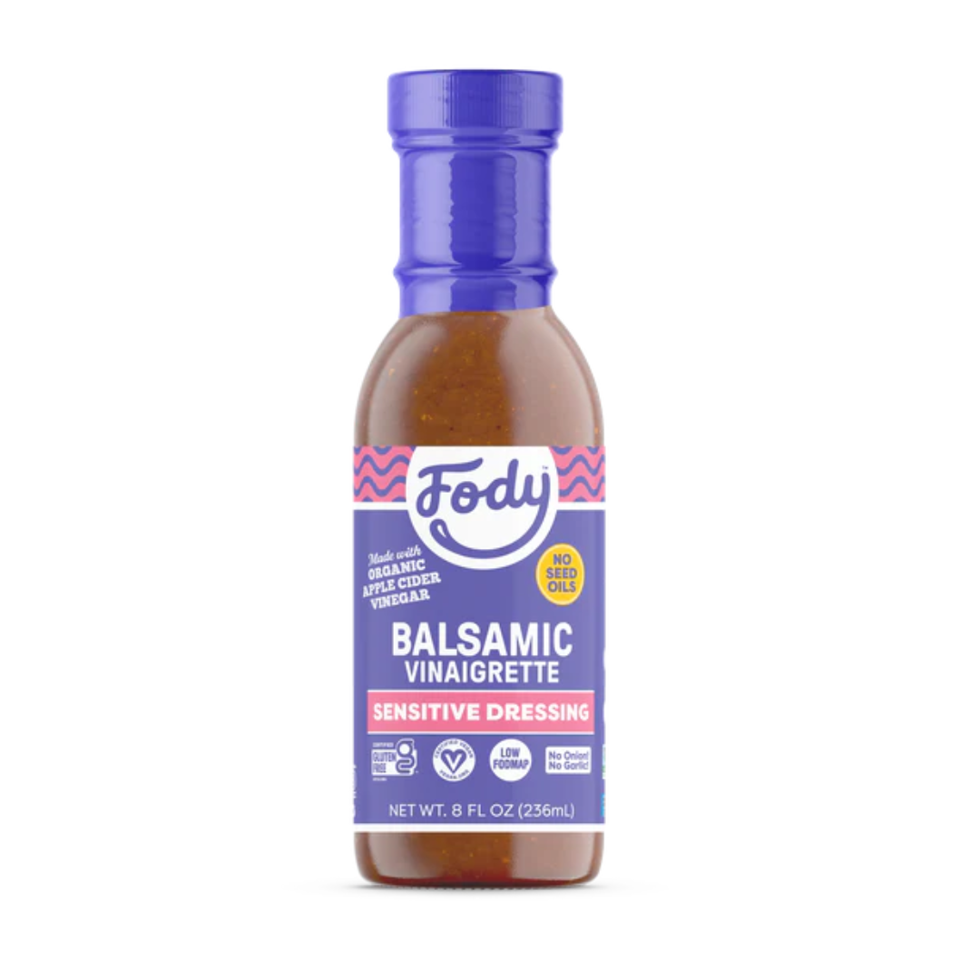 A bottle of Fody Balsamic Vinaigrette salad dressing with a blue and purple label, made with organic apple cider vinegar and no seed oil. This 8 fl oz (236 ml) dressing is perfect for adding classic balsamic vinegar flavour to your salads.