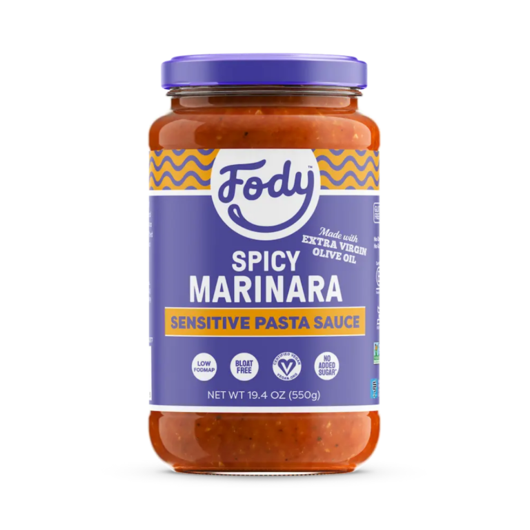 A jar of Fody brand Spicy Marinara Pasta Sauce, inspired by Arrabbiata, features a purple and yellow label with product info, including low FODMAP, gluten free, no onion or garlic, and a net weight of 19.4 oz (550g).